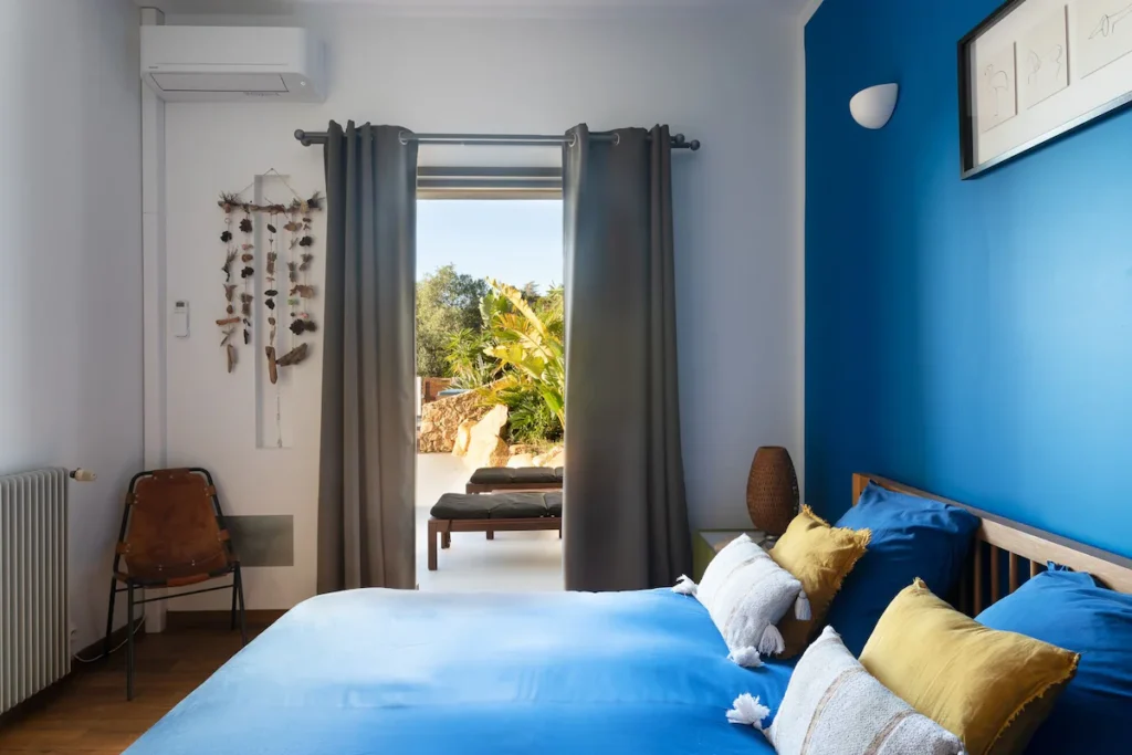 Chambre avec un lit double donnant accès sur la terrasse.