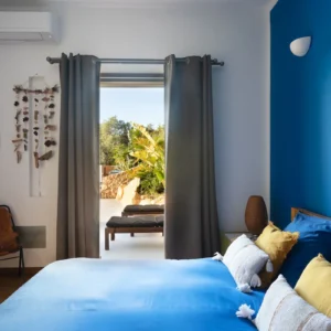 Chambre avec un lit double donnant accès sur la terrasse.