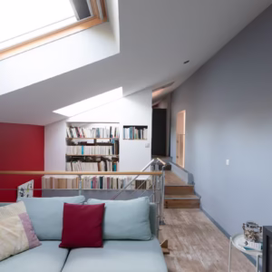 Espace de détente avec bibliothèque et télévision.