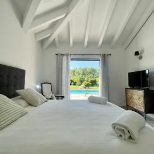 Chambre avec grand lit KingSize avec accès direct à la terrasse et sa piscine.
