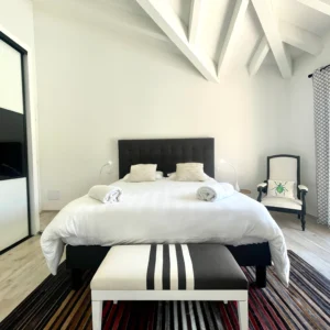Chambre noir et blanche avec grand lit KingSize avec accès direct à la terrasse et sa piscine.