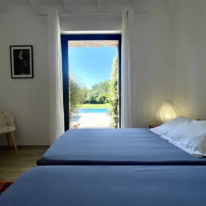 Chambre avec 2 lits doubles et accès terrasse extérieure sur la piscine.