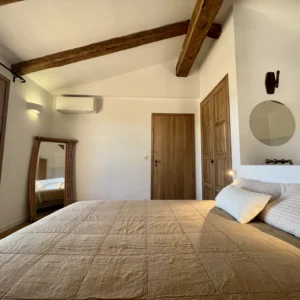 Grande chambre avec lit king size, placard et salle de bain et miroir.