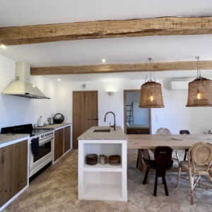 Cuisine équipée avec décoration bois et charpente.
