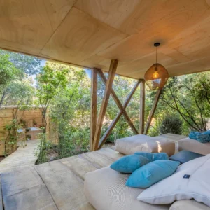 Grand espace repos sous la maison avec canapé et coussins