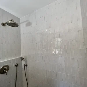 Grande douche italienne avec carreaux blanc.