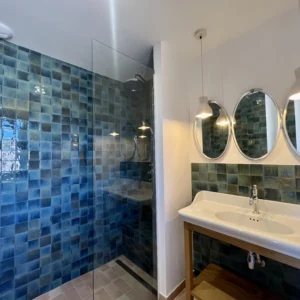 Grande salle de bain avec triple miroir offrant une grande luminosité.