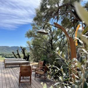 Terrasse en bois équipée de sa douchette collée au maquis corse.