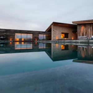 Magnifique reflet de la villa sur l'eau de la piscine à la tombée de la nuit.