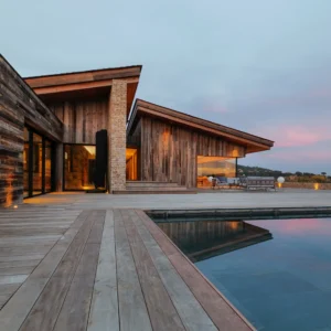 Vue villa et piscine au couché du soleil.