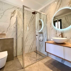 Salle de bain moderne en marbre et lumineuse.