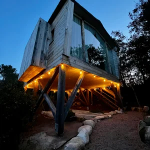 Vue sur la cabane perchée de nuit et sa terrasse extérieure