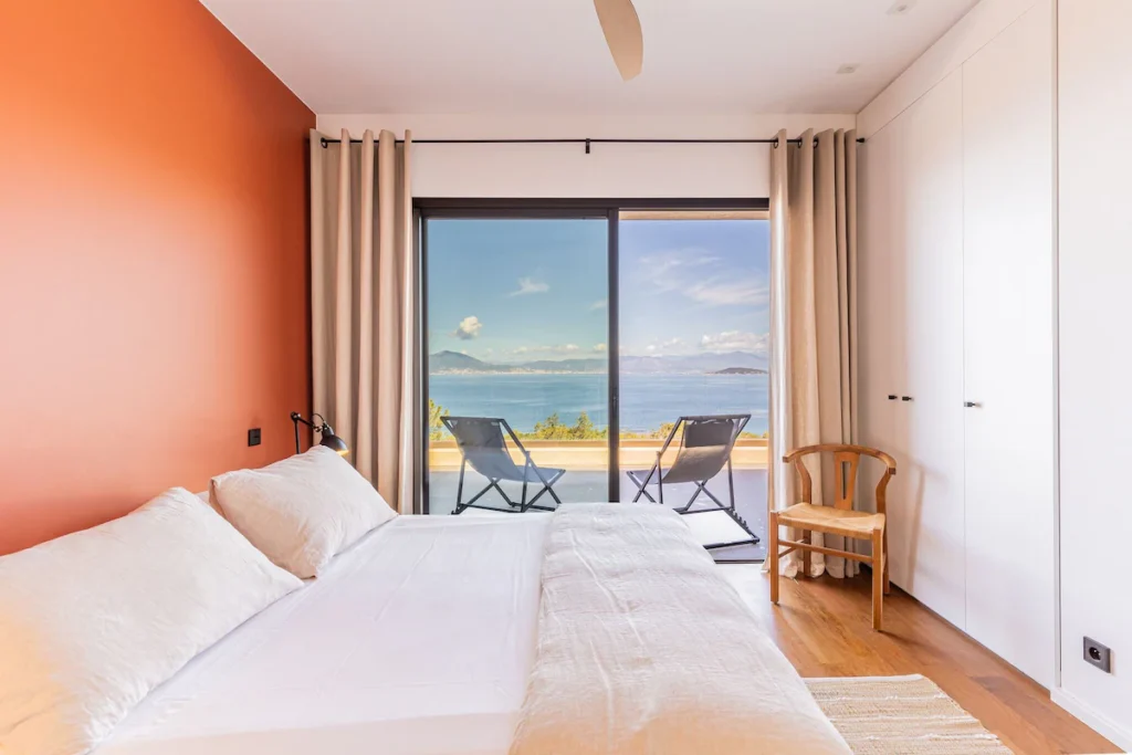 Chambre colorée d'orange de la Villa Fioraventi et une magnifique vue mer sur le golf d'Ajaccio.
