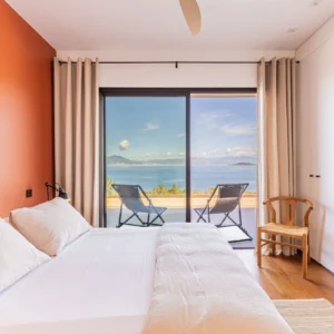 Chambre colorée d'orange de la Villa Fioraventi et une magnifique vue mer sur le golf d'Ajaccio.