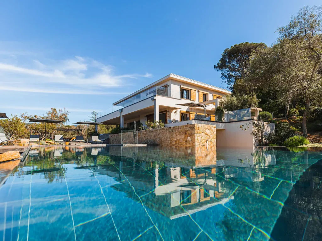 Vue sur la grande piscine et la façade de la villa Fioraventi en Corse du sud.