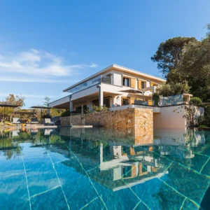 Vue sur la grande piscine et la façade de la villa Fioraventi en Corse du sud.