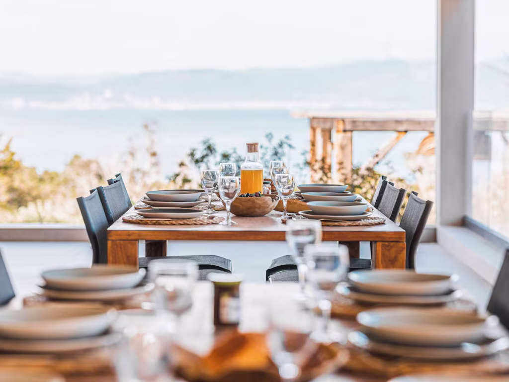 Deux tables à manger en bois décoré d'un petit déjeuner avec une vue mer saisissante.